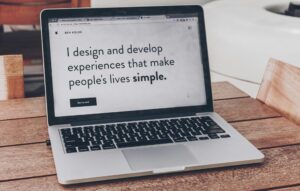 Laptop screen reading 'I design and develop experiences that make people's lives simple.'