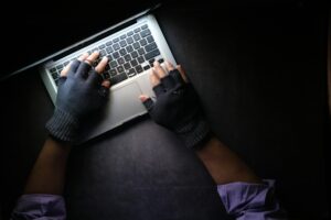 gloved hands typing on a keyboard