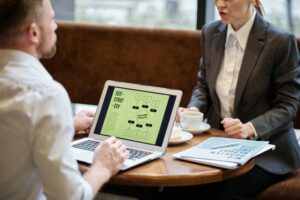 two people sat at a table with a laptop screen showing an SEO strategy visible