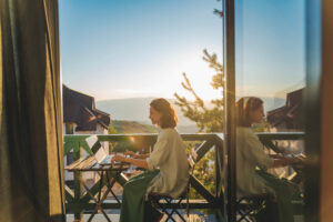 woman sat at laptop on balcony