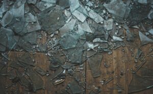 Fragments of shattered glass on a wooden floor