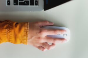 Hand on mouse from above.