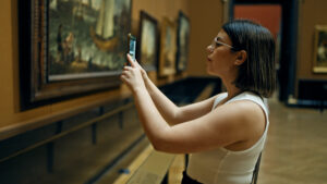 A woman taking a photo in an art gallery